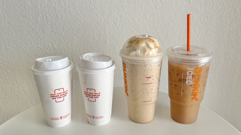 Four Dunkin' drinks lined up on a table