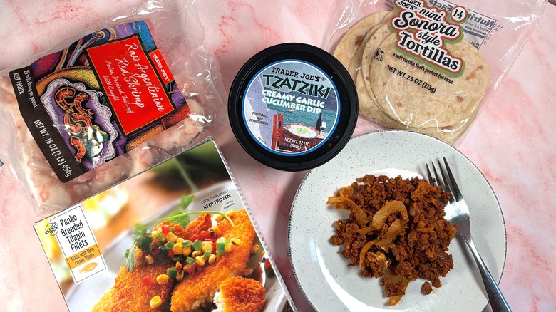 Various Trader Joe's packaged foods and plated soy chorizo scramble on pink table