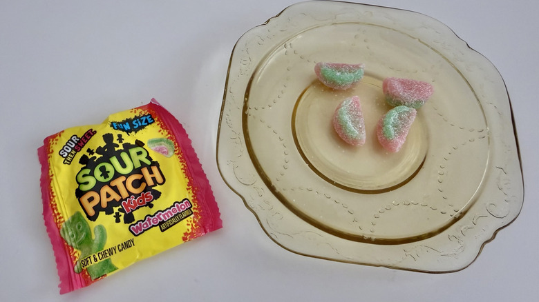 Four pieces of Watermelon Sour Patch Kids on a plate