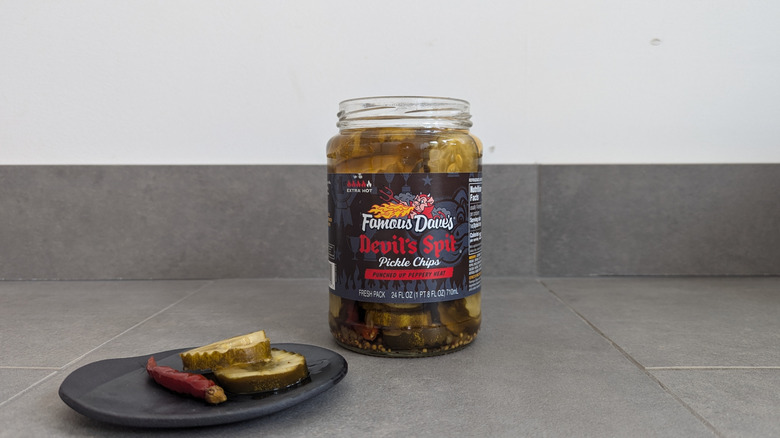 Famous Dave's pickle jar next to pickle chips on a plate