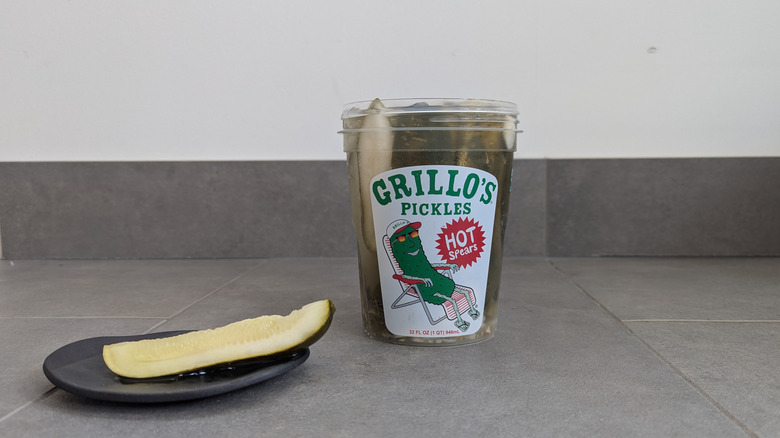 Clear container of Grillo's Pickles with a cartoonish pickle illustration