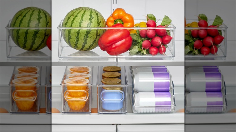 Four iDESIGN kitchen bins in refrigerator filled with food and drinks
