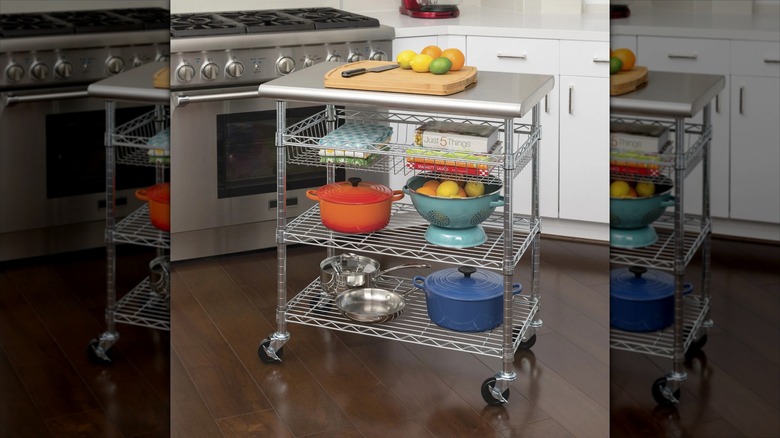 Seville Classics stainless steel kitchen cart in kitchen with cutting board on top and items on shelves