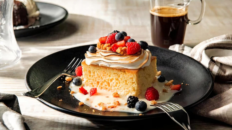 Fogo de Chao tres leches cake on a plate with berries.