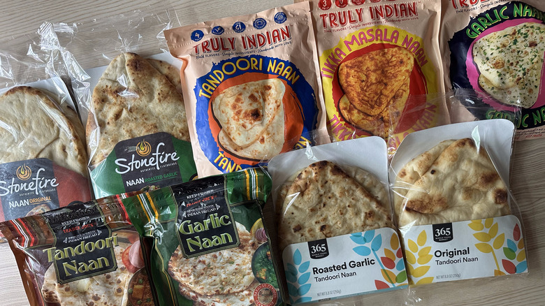 Packages of store-bought naan on wooden table