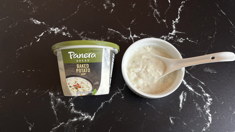 Panera baked potato soup container next to bowl of soup