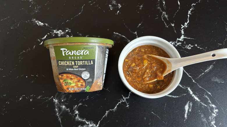 Panera chicken tortilla soup container next to bowl of soup
