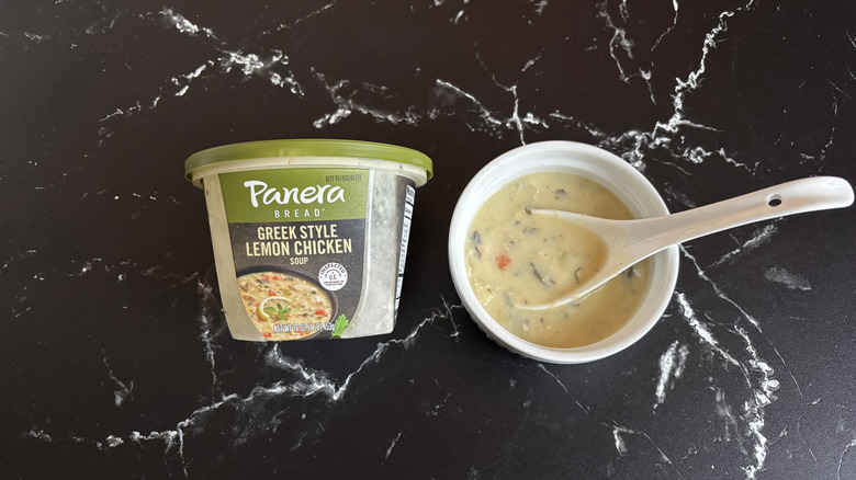 Panera Greek style lemon chicken soup container next to bowl of soup