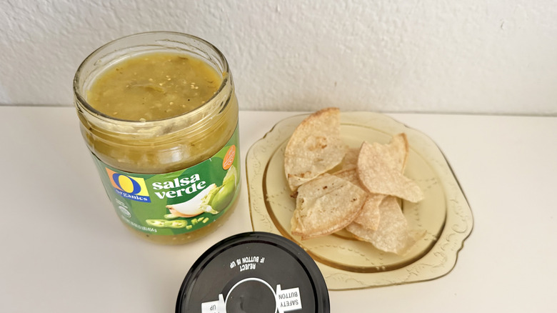 O Organics Medium Salsa Verde jar on a table with some chips