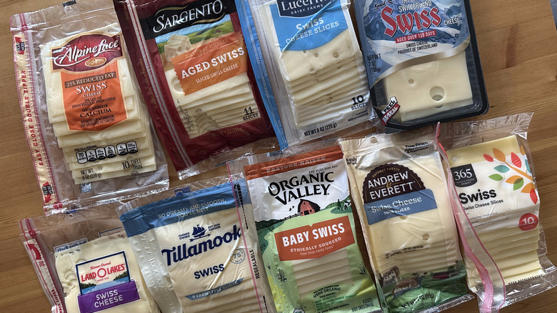 Packages of Swiss cheese on wooden table