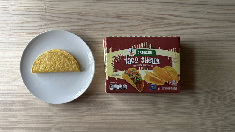 Stop and Shop Crunchy Taco Shells brand on wooden table with one shell on a plate