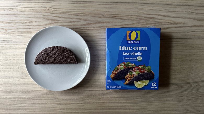 O Organic Blue Corn Taco Shell on a plate on a wooden table with box on the side