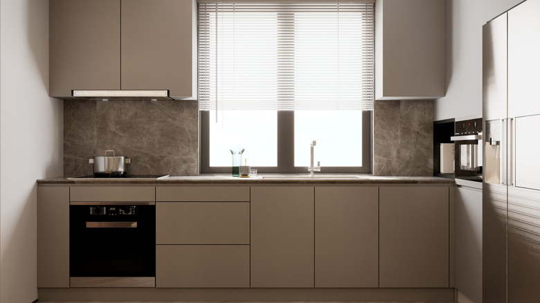 Warm greige kitchen with silver countertop and gray stone backsplash