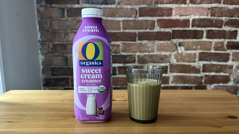 O Organics Sweet Cream Coffee Creamer and cup of coffee on wooden table with a brick background