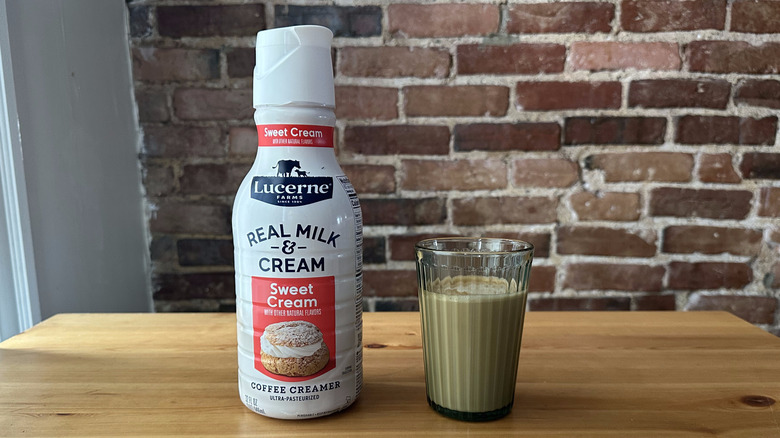 Lucerne Real Milk and Cream Sweet Cream Coffee Creamer and cup of coffee on wooden table with a brick background