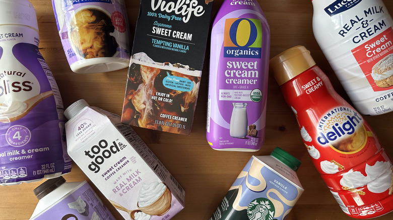 Various sweet cream coffee creamers arranged on wooden table