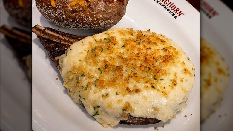 Parmesan-crusted bone-in ribeye with loaded baked potato on LongHorn plate.