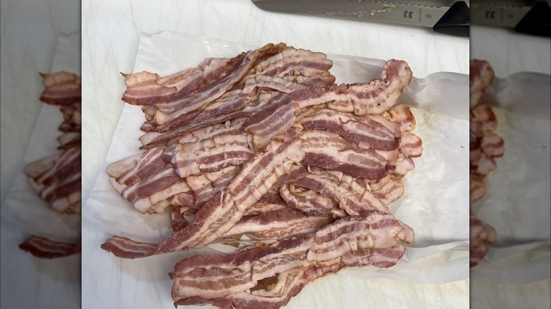 Pile of bacon on chopping board, mirrored image