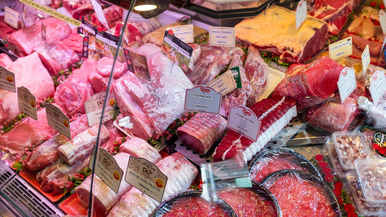 Variety of products sealed and packaged in meat butcher display case.