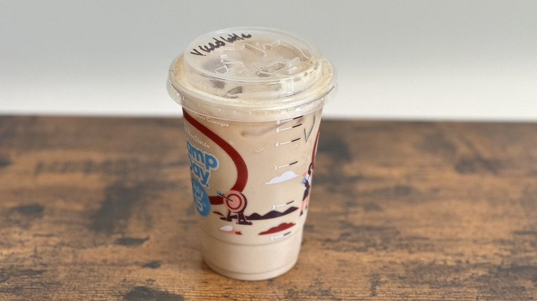 Plastic cup of Tim Hortons Iced Vanilla Latte on wooden table