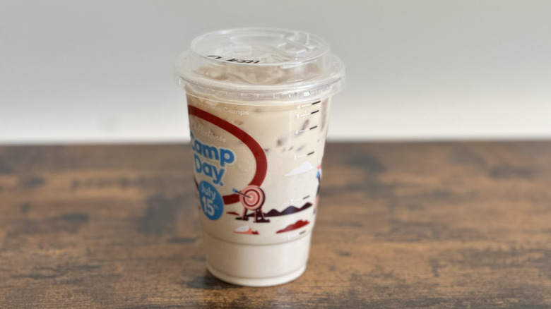 Plastic cup of Tim Hortons Iced Coffee on wooden table