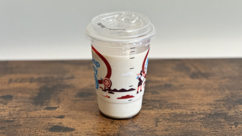 Plastic cup of Tim Hortons Iced Chai Latte on wooden table