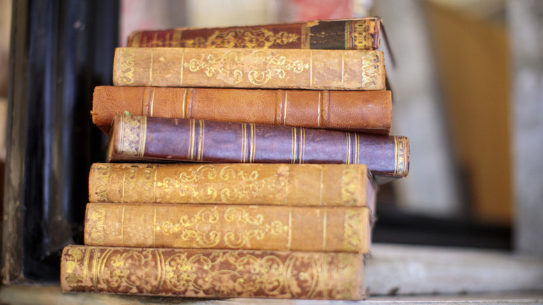 Stack of very old books against a blurred background
