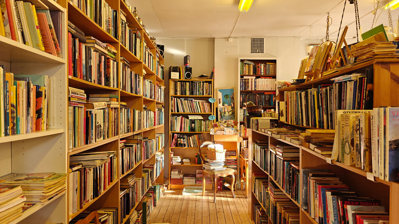 Inside a second-hand bookstore, with lots of book-filled shelves and an old chair