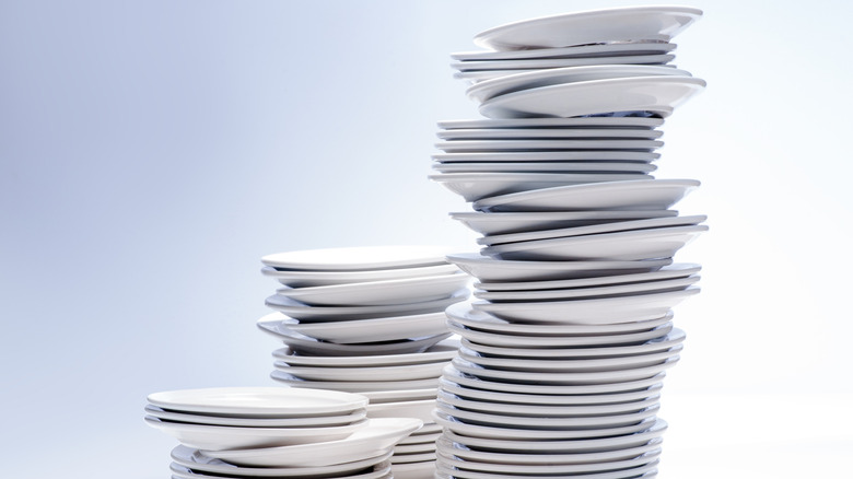 Three stacks of white plates placed on top of each other.
