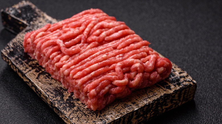 Ground beef sitting on a wooden cutting board