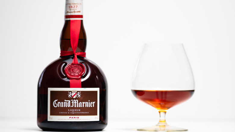 A bottle of Grand Mariner next to a cognac glass