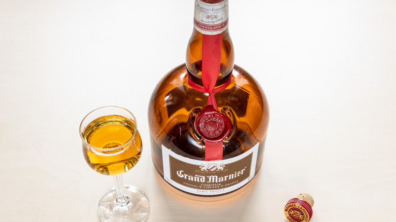 A bottle of opened Grand Mariner with some poured into a glass
