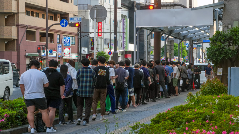 long line of people in Japan waiting for food at a ramen shop