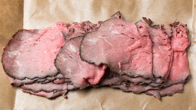 thinly sliced roast beef on paper