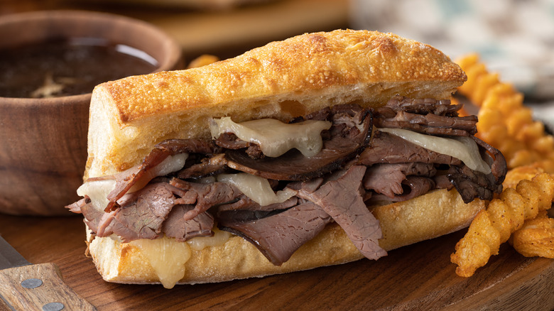 hot roast beef sandwich in a crispy baguette with cheese oozing out