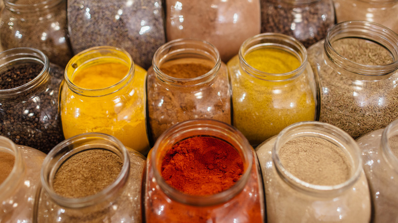 Large jars of colorful assorted spices