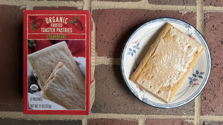 Box of Trader Joe's toaster pastries next to unwrapped pastry with light glaze of icing on plate