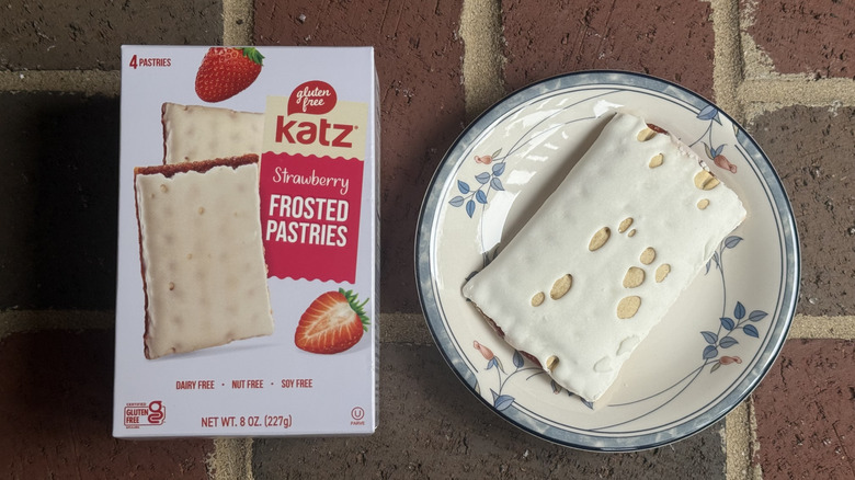 Box of Katz gluten-free strawberry frosted pastries next to unwrapped pastry with plenty of frosting on plate