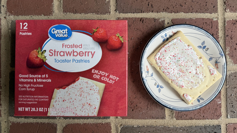 Box of Great Value strawberry toaster pastries next to unwrapped pastry with plenty of sprinkles on plate