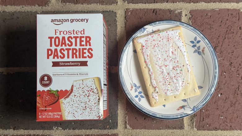 Box of Amazon Grocery strawberry toaster pastries next to unwrapped pastry flecked with sprinkles on plate