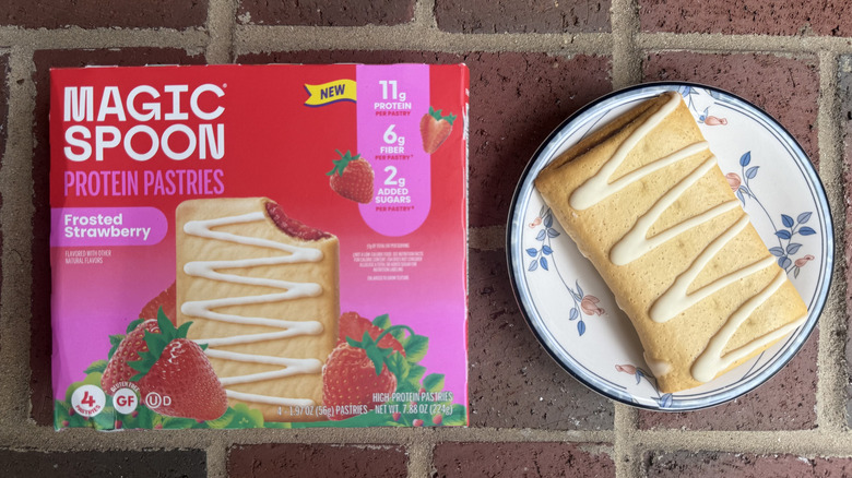 Magic Spoon protein pastry box beside unwrapped pastry with drizzle of icing on plate