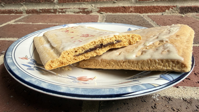 Two toaster pastries on plate, one sliced open to show strawberry filling