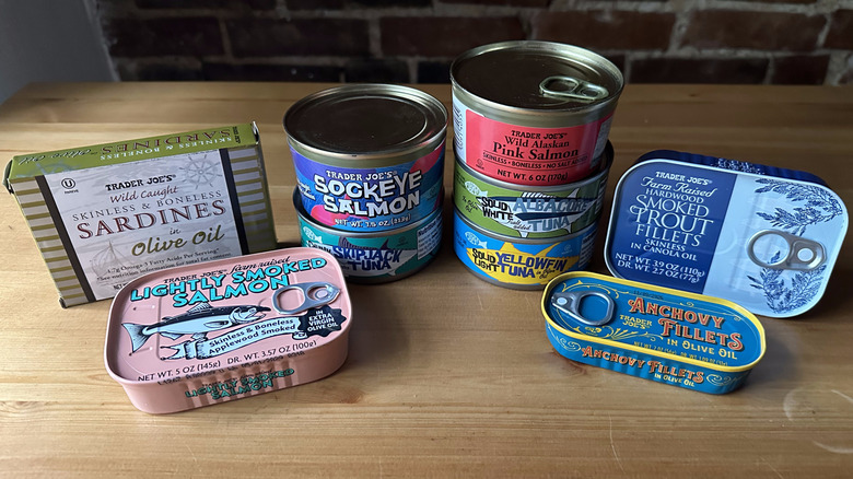 Variety of Trader Joe's canned fish on wooden table