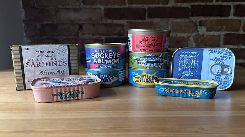 Variety of Trader Joe's canned fish on wooden table