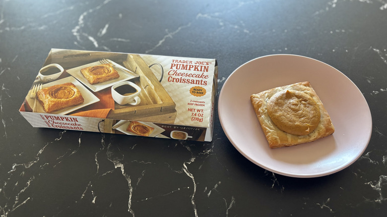 Trader Joe's pumpkin cheesecake croissants box next to pumpkin croissant on plate
