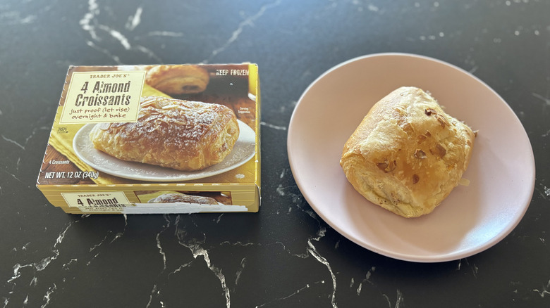 Trader Joe's almond croissant box next to almond croissant on plate