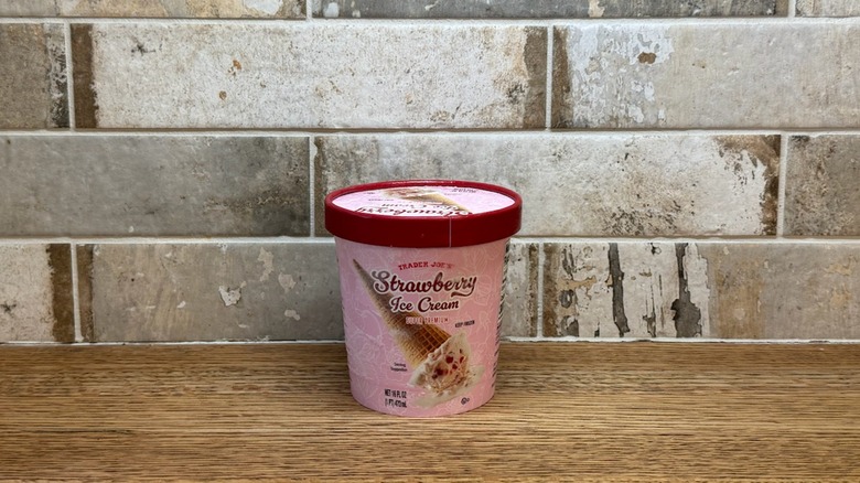 Trader Joe's Strawberry ice cream in a tub on a wooden counter