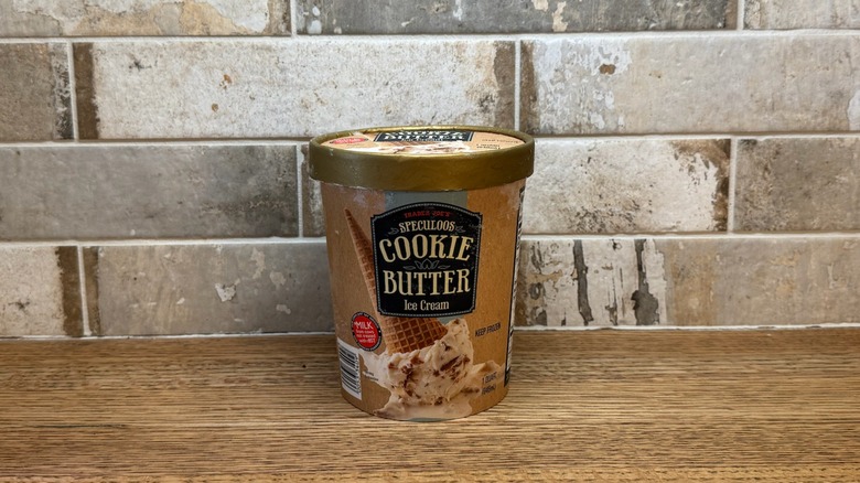 Trader Joe's Speculoos Cookie Butter ice cream in a tub on a counter with a brick background