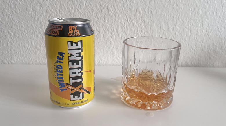 Open can of Extreme Long Island Iced Tea Twisted Tea next to a glass