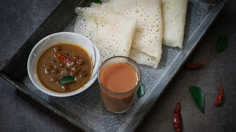 Neer dosa on serving tray with chai and chickpea curry